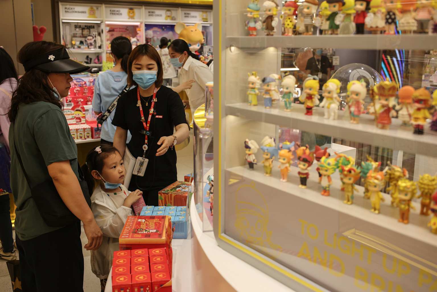 Customers browse and shop for collectible blind box figures inside a Pop Mart retail store.
