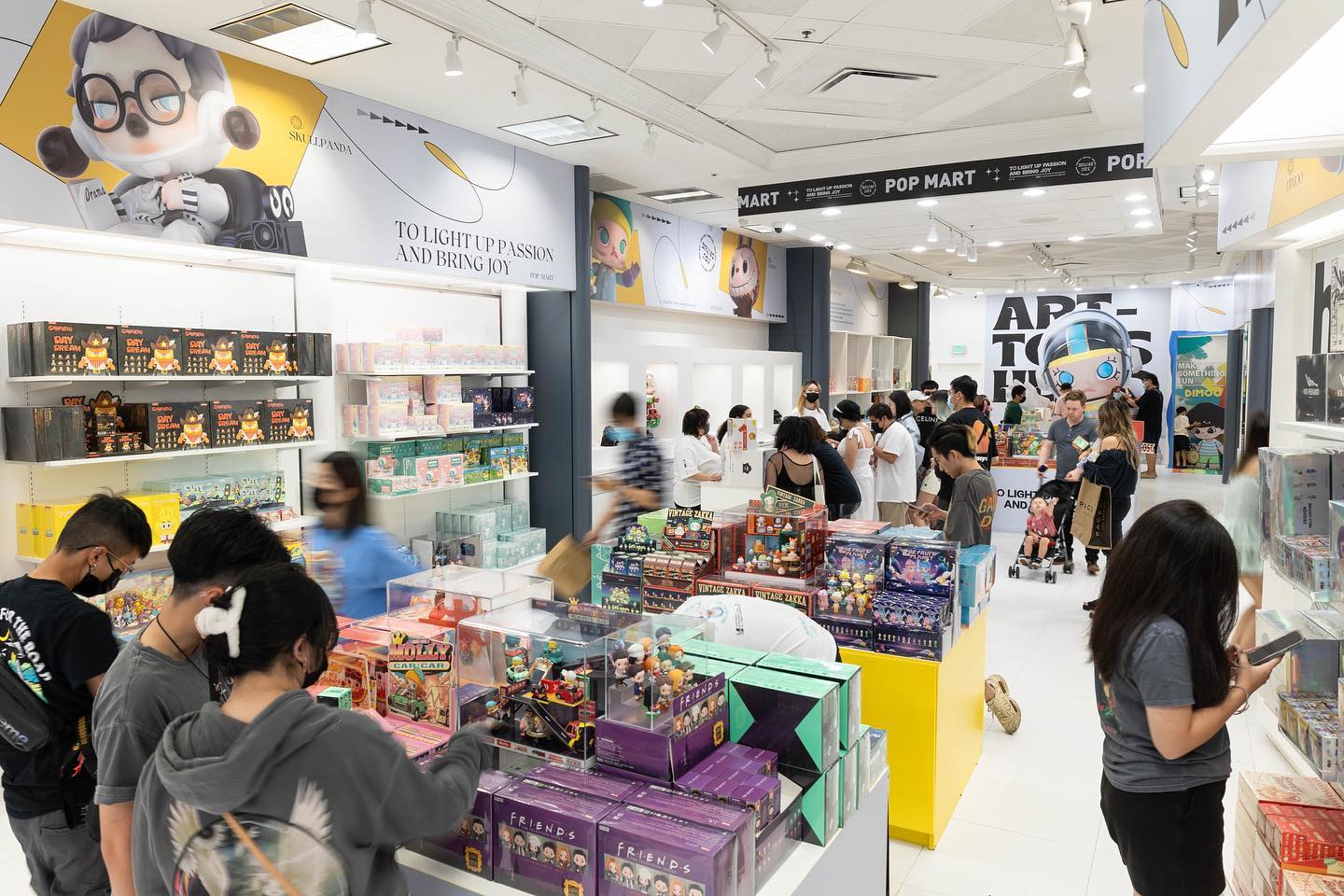 Customers browse a vibrant selection of collectible art toys inside a Pop Mart retail store, showcasing the brand's successful physical presence during its international expansion.